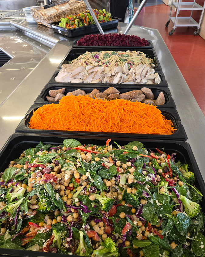 More freshly made salad, sausage, grilled chicken, vegetables, and fruits.