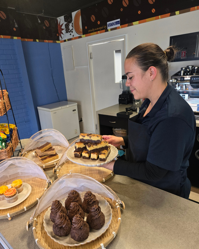 Café Assistant Hine arranging sweets for the Café.
